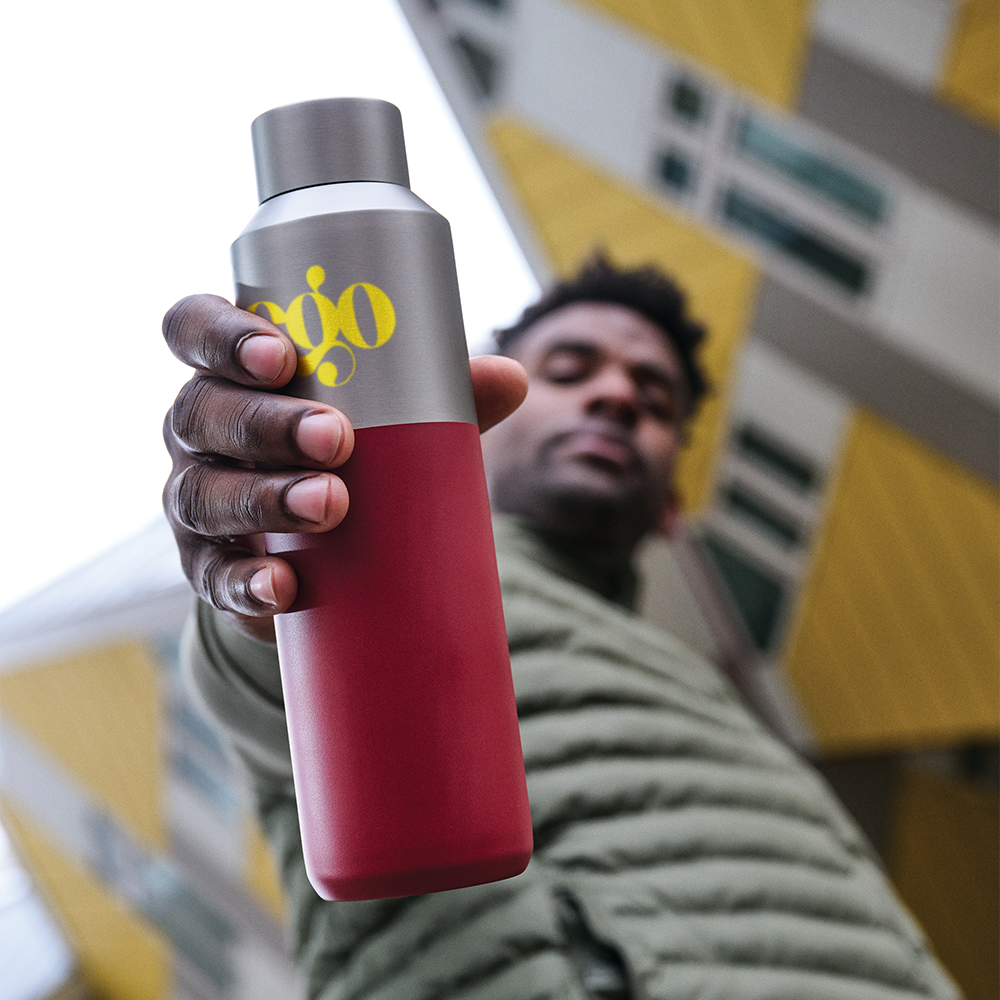 Man holding a red Fluid RCS water bottle with custom yellow ego print