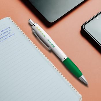 Stylo Nash deluxe blanc avec impression de logo multicolore et grip vert posé sur un carnet à spirale ouvert à côté d'un téléphone