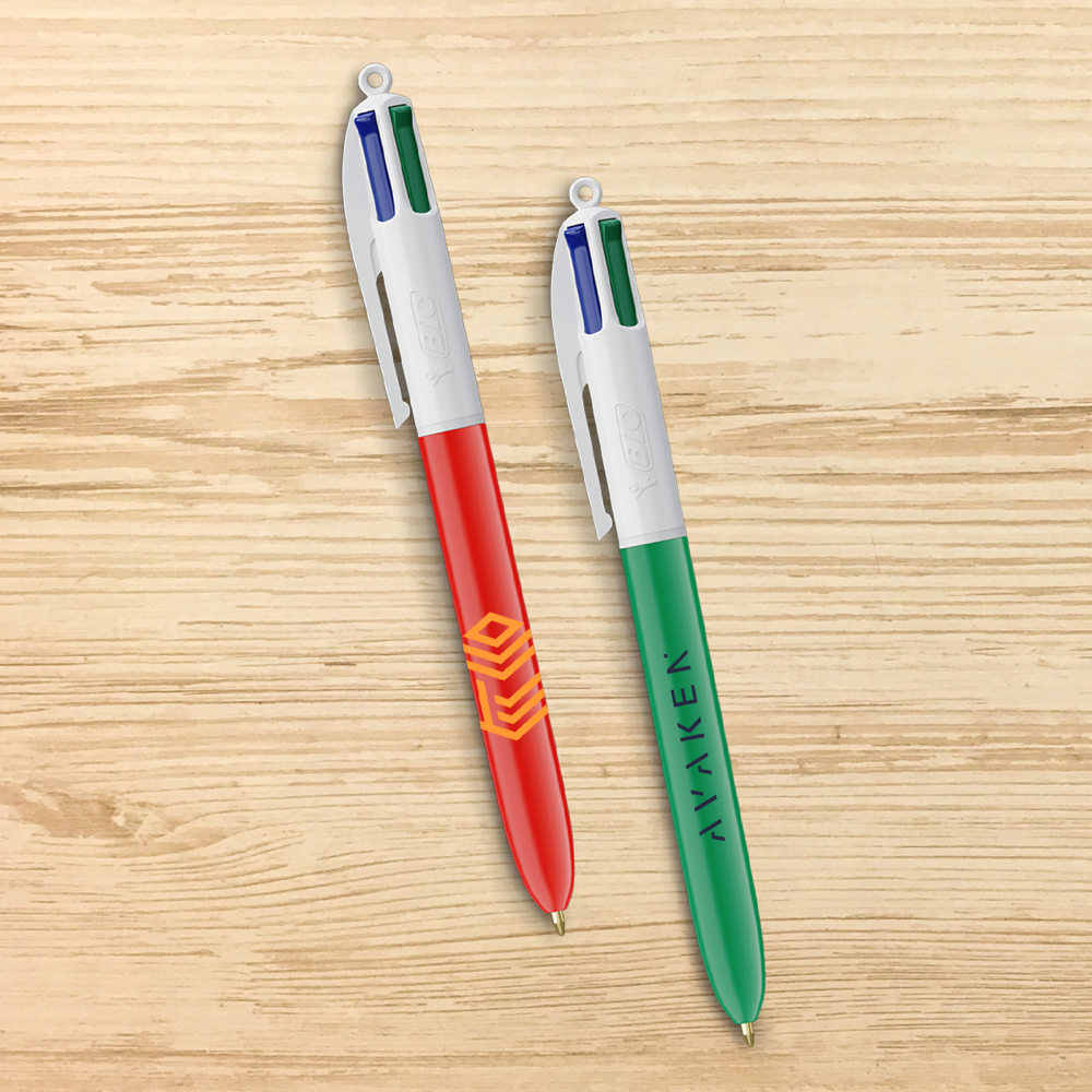 Red and green BIC 4 Colours ballpoint pens on a wooden surface