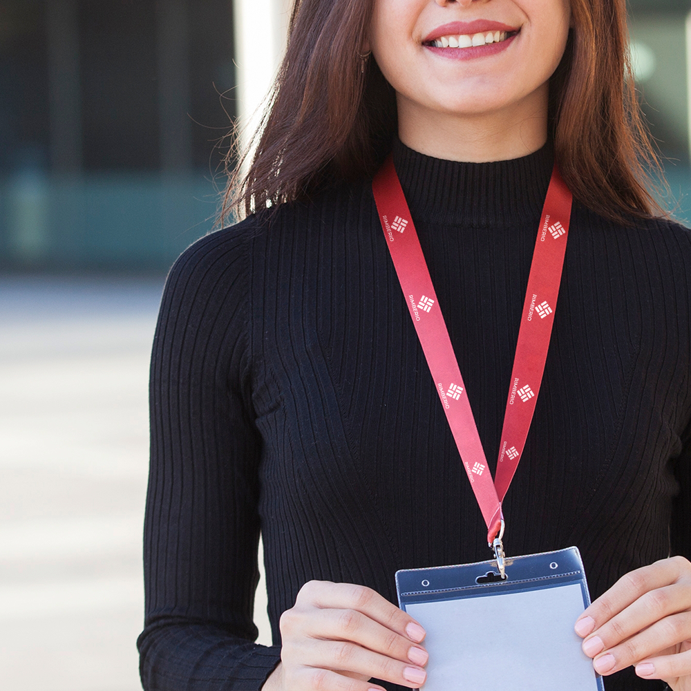Smiling woman wearing red printed lanyard with clear name badge holder