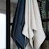 Drei klassische Handtücher in Marineblau, Anthrazit und Beige in einem Badezimmer