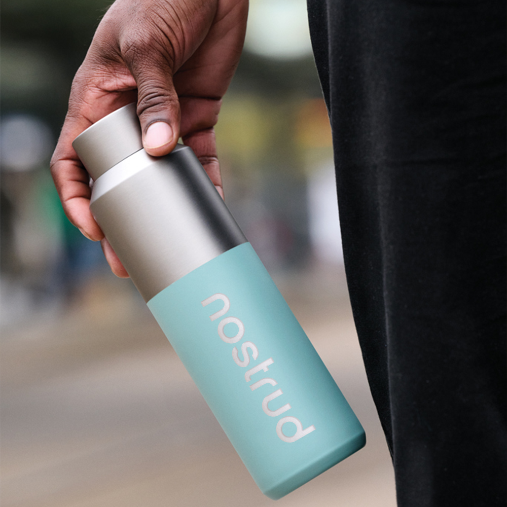 Hand holding a mint green Fluid RCS water bottle with white logo print