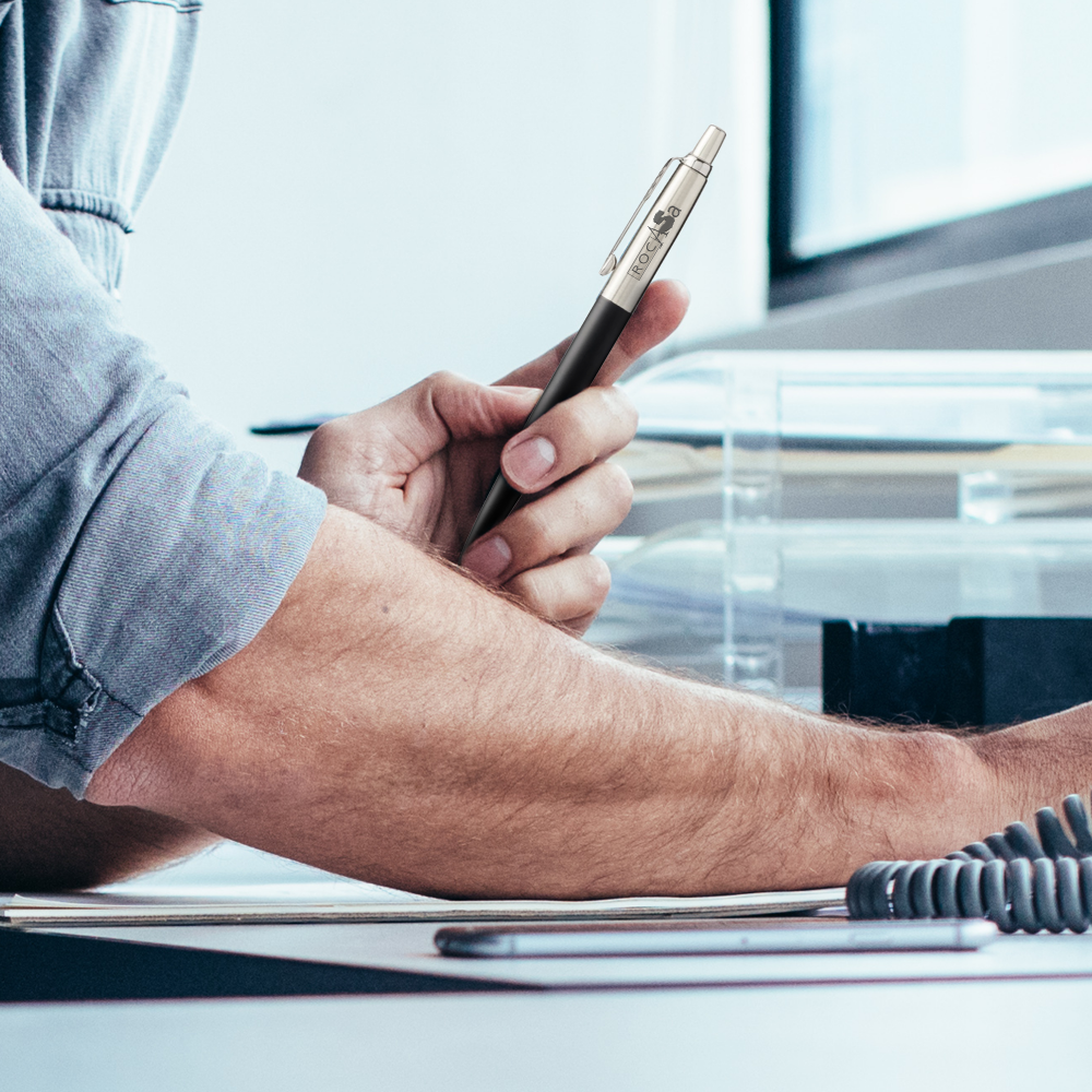 Person holding a Parker Jotter Bond Street ballpoint pen at a desk