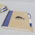 Recycled kraft notebook with blue spine and printed logo beside a white pen