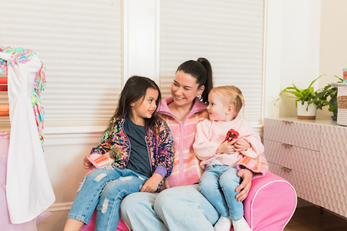 A caregiver sitting with children in a bright, welcoming home