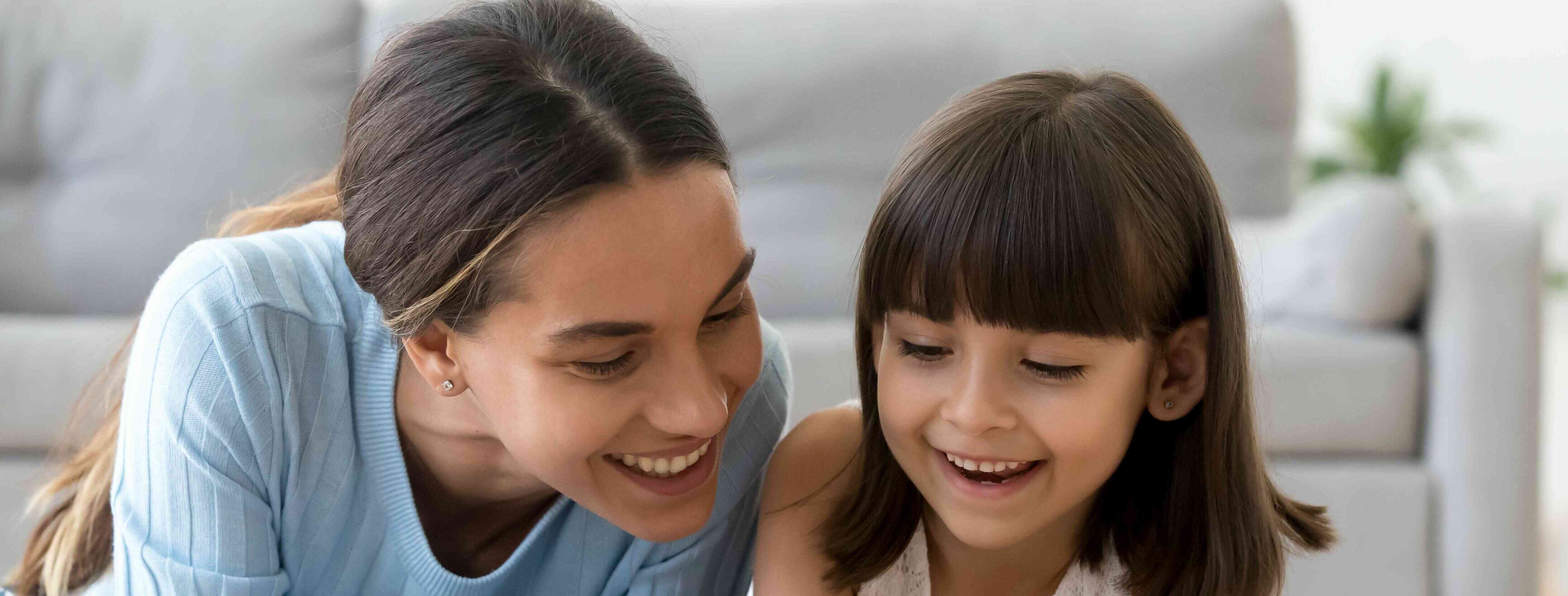 Portuguese-speaking child care provider spending time with a girl.