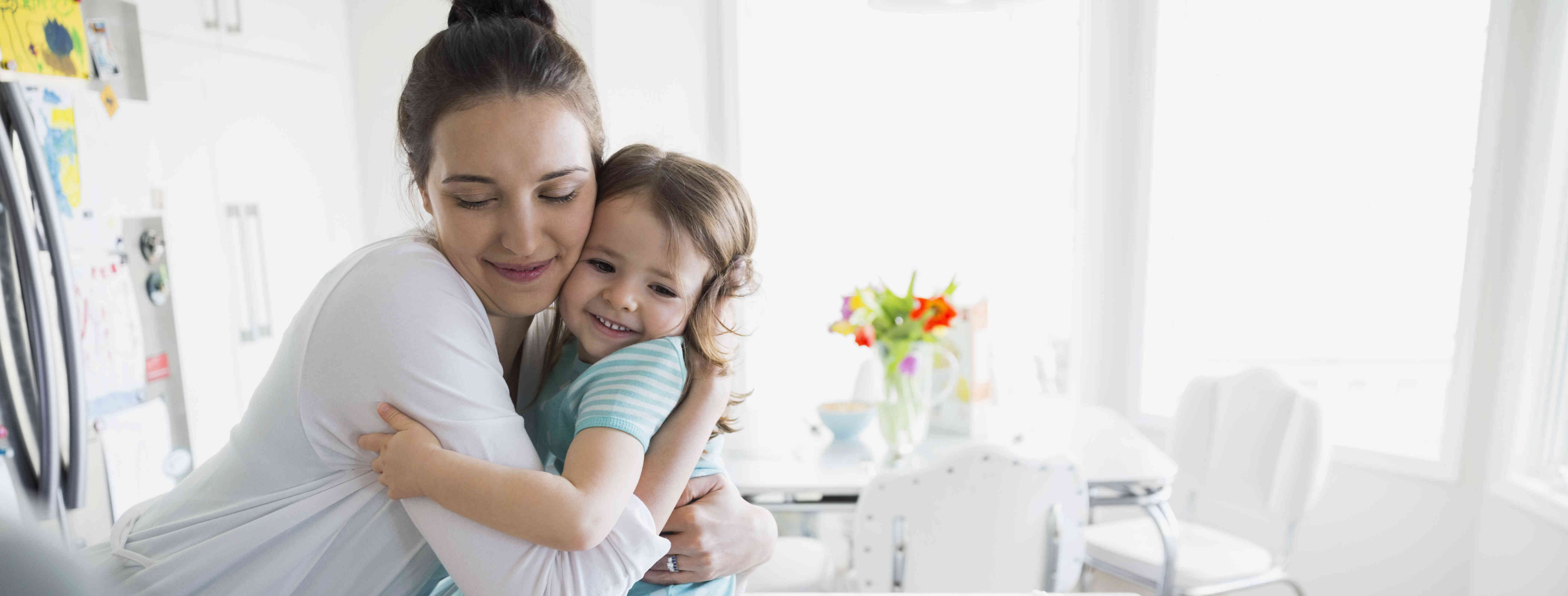 Child care provider hugging a little girl.