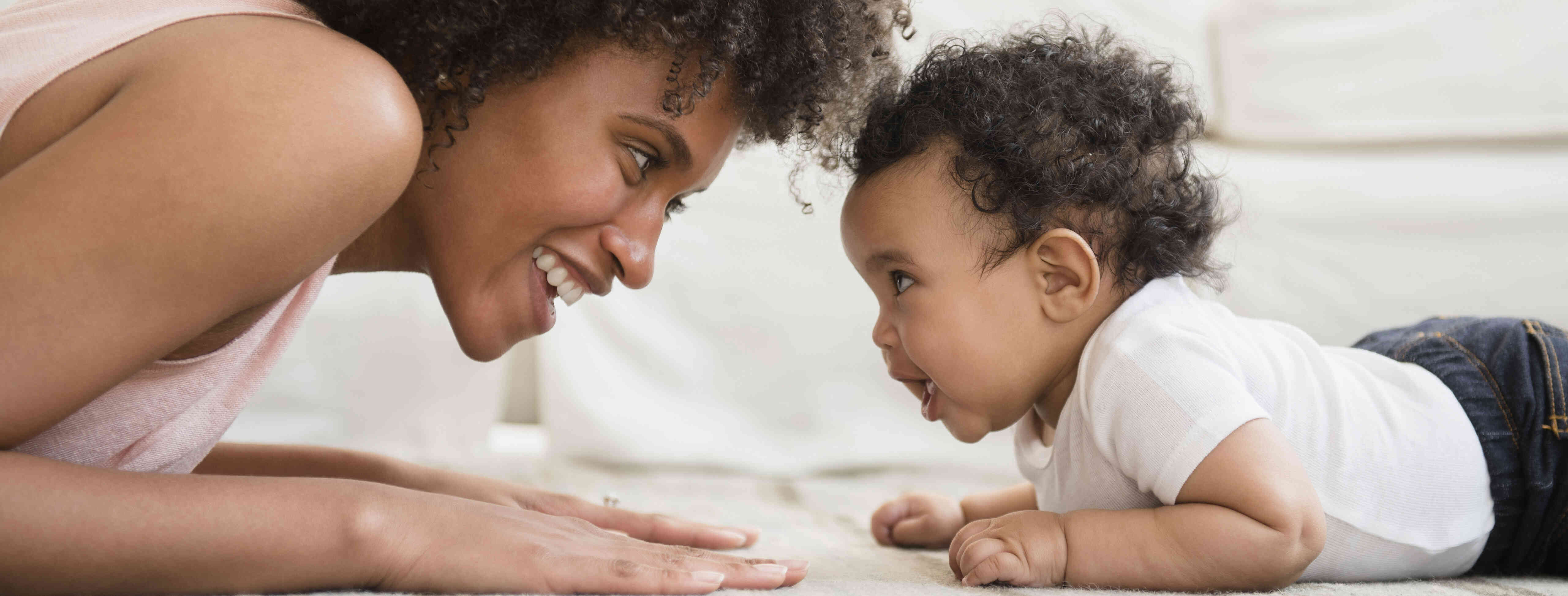 child care provider playing with and talking to an infant