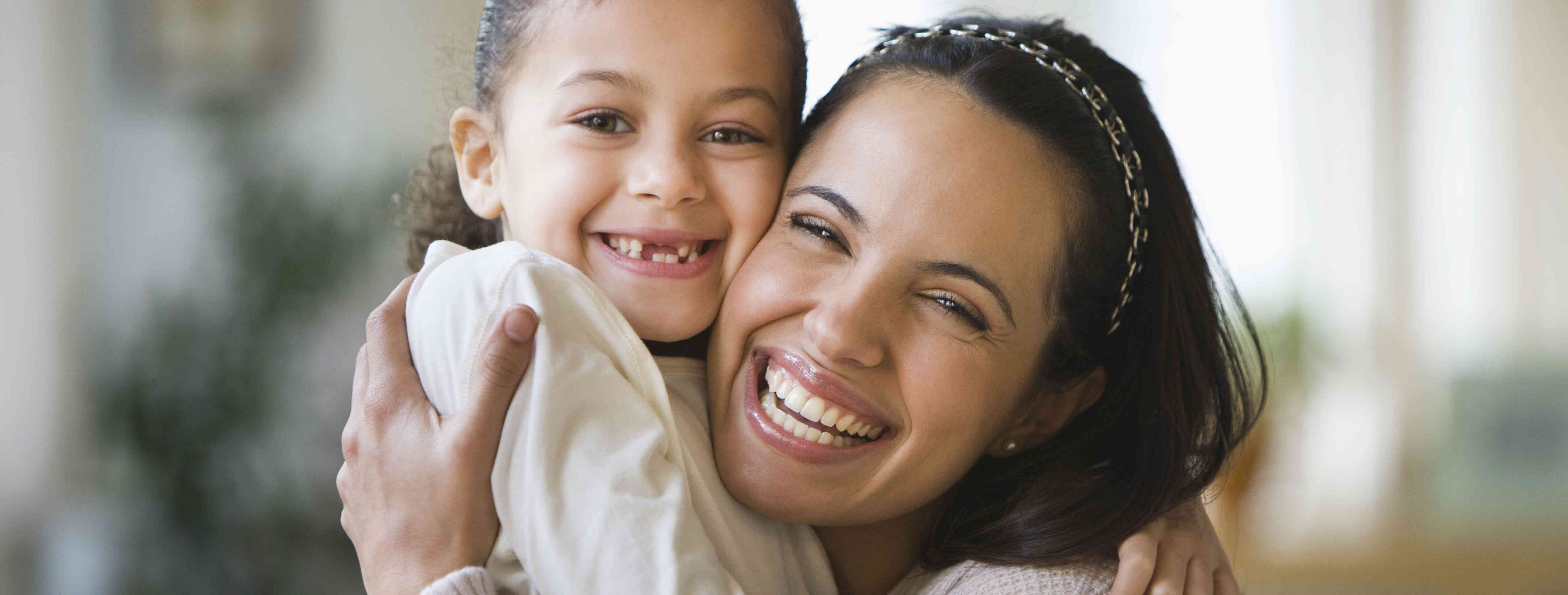 child care provider and child hugging