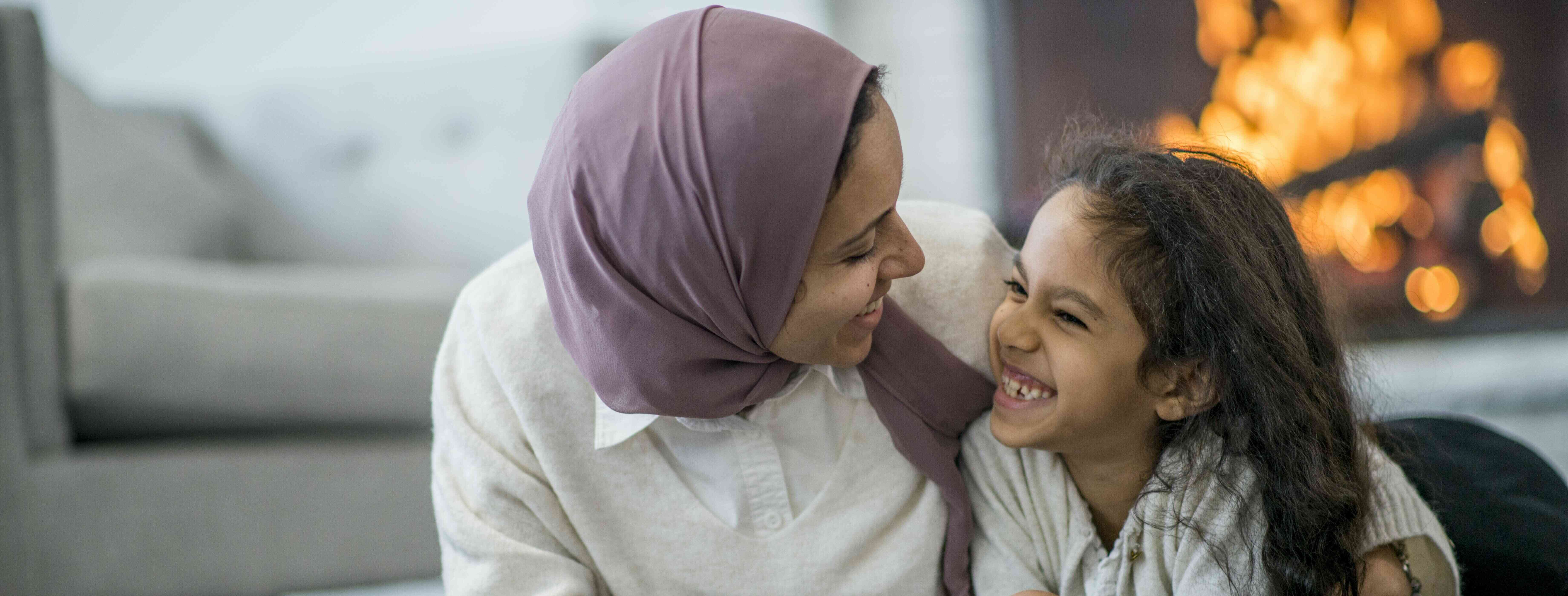 Arabic-speaking child care provider hanging out with a girl