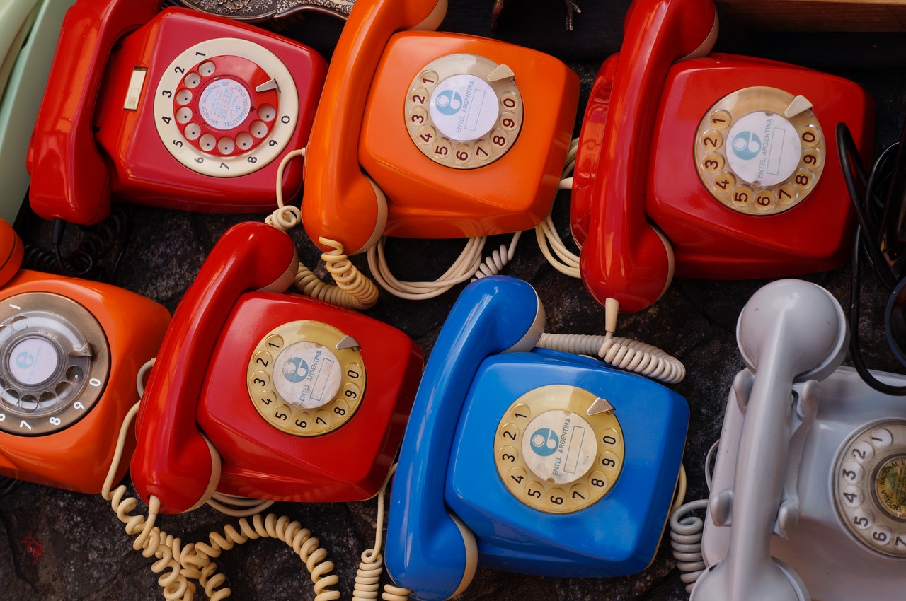 seven assorted colored rotary telephones