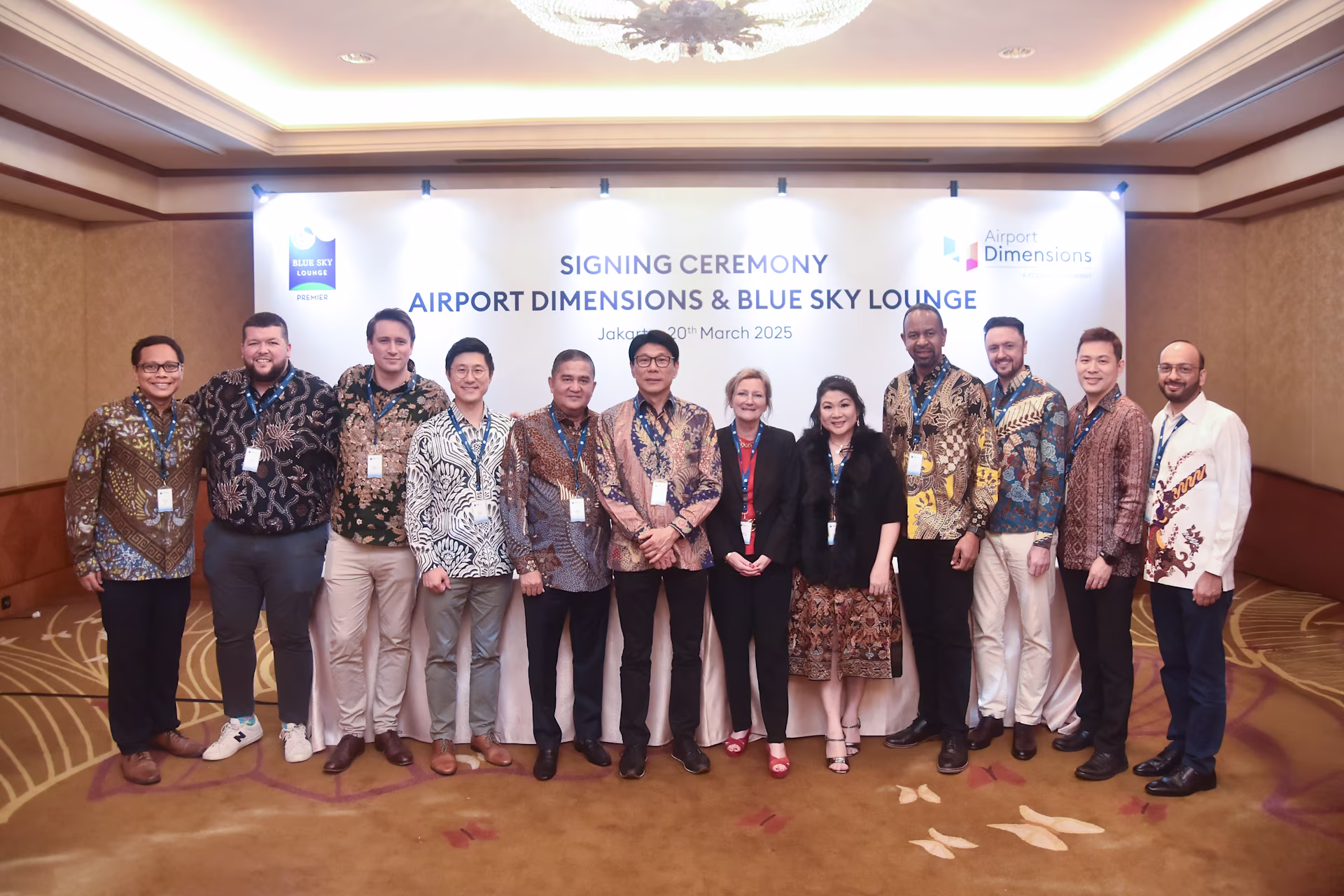 Group of men and women standing in front of banner