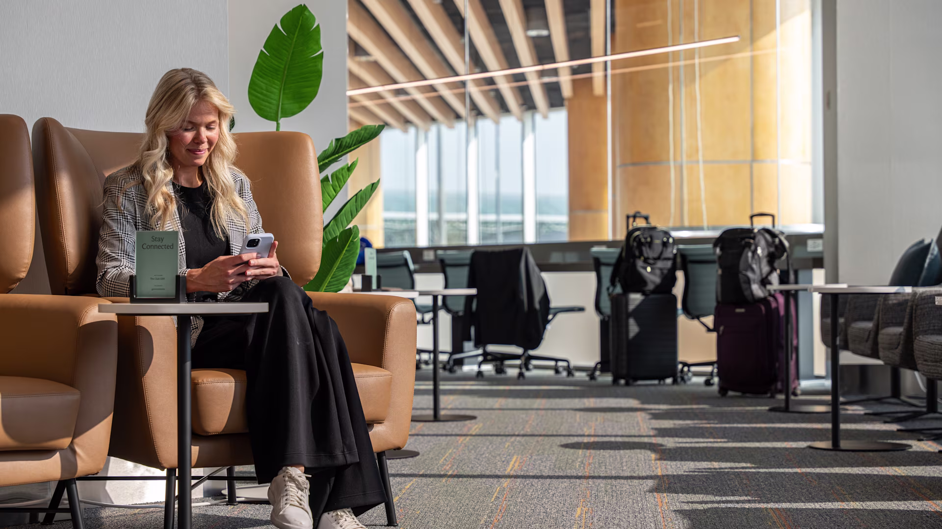 The Club airport lounge seating area with women on her phone