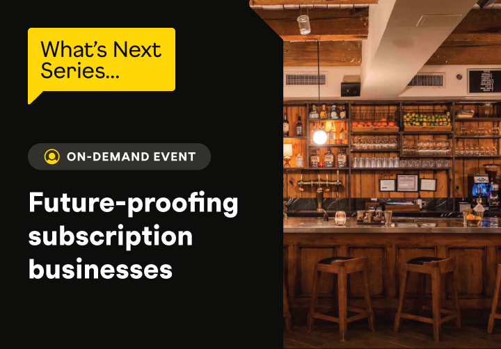 A cozy bar interior with wooden shelves, bottles, and a sign promoting an on-demand event about subscription businesses.