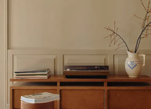 Panelled wall in KABRIC Mushroom behind a sideboard with a record player, vinyl records and a jug of berry branches.