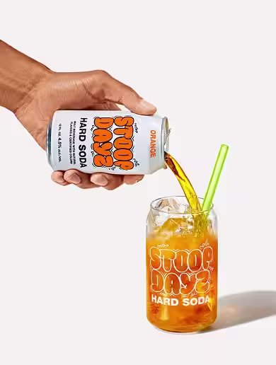 Orange Stoop Dayz Hard Soda being poured into a glass
