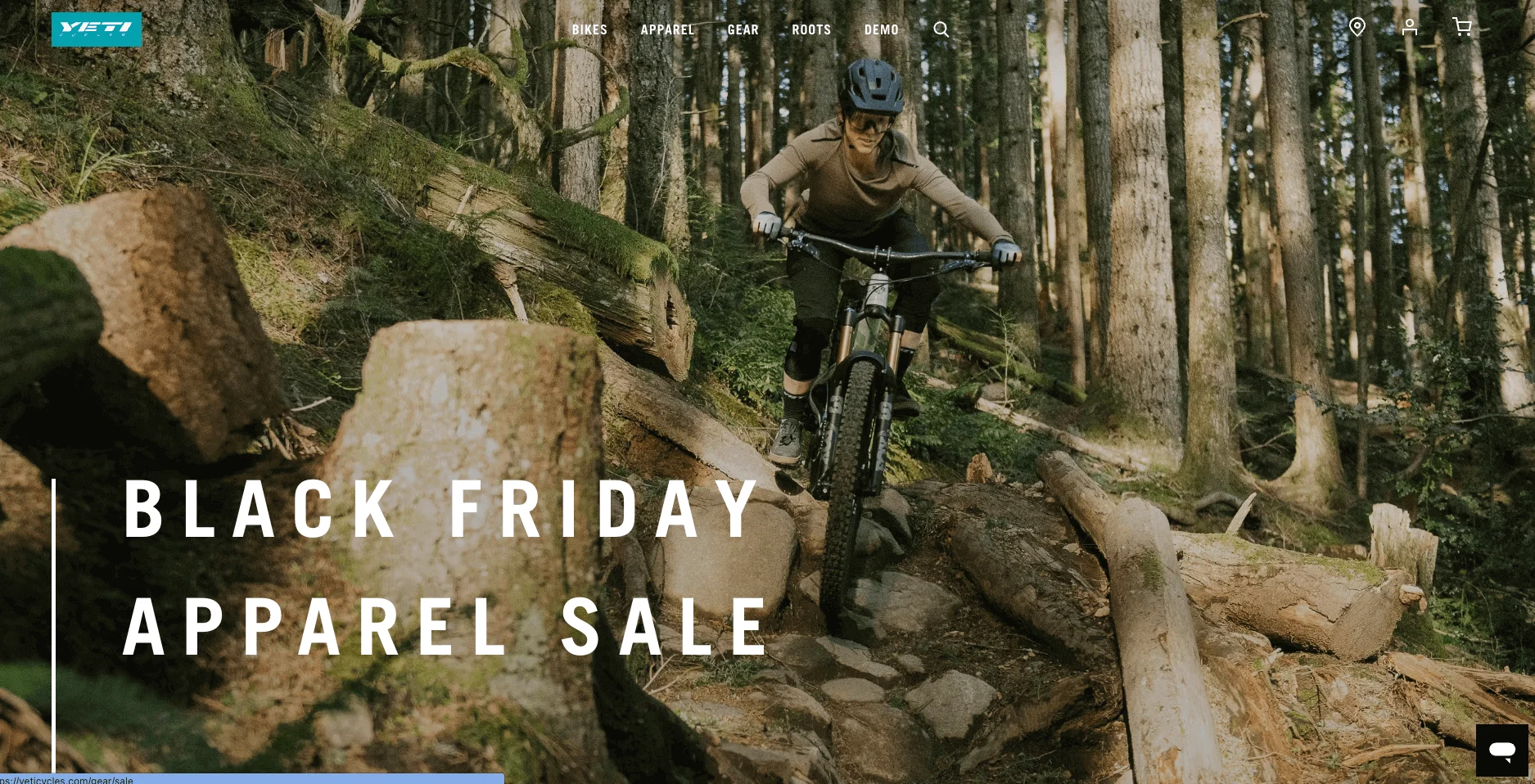 Person mountain biking down a rocky forest trail with sunlight filtering through trees, Black Friday Apparel Sale text overlaid.