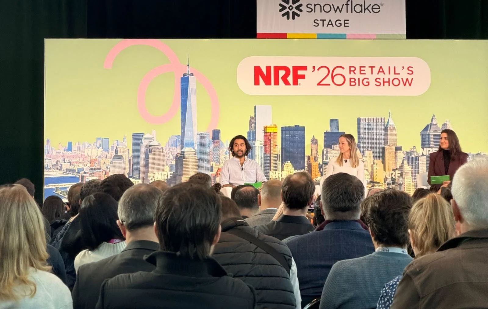 Retail technology experts presenting on the Snowflake Stage during the NRF 2026 event at the Javits Center.