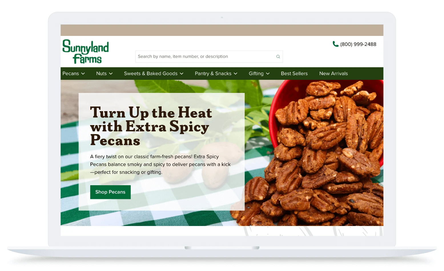 A laptop screen shows a website with a bowl of spicy pecans and text promoting extra spicy pecans for snacking.