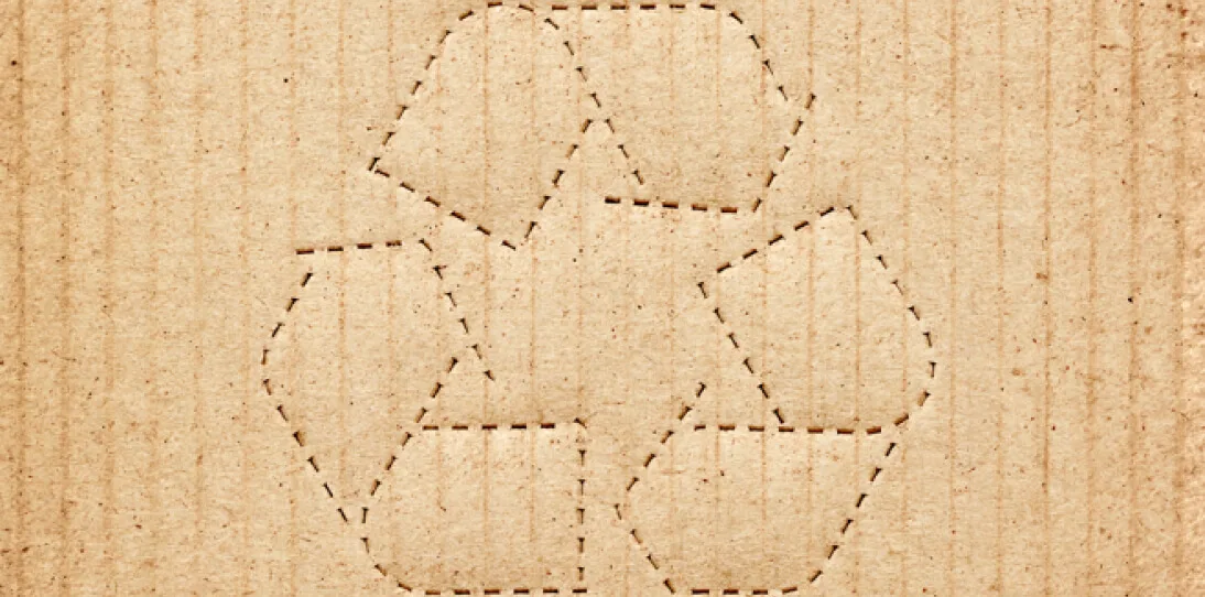 Recycling symbol outlined with dashed lines on a brown cardboard background, emphasizing eco-friendly packaging.