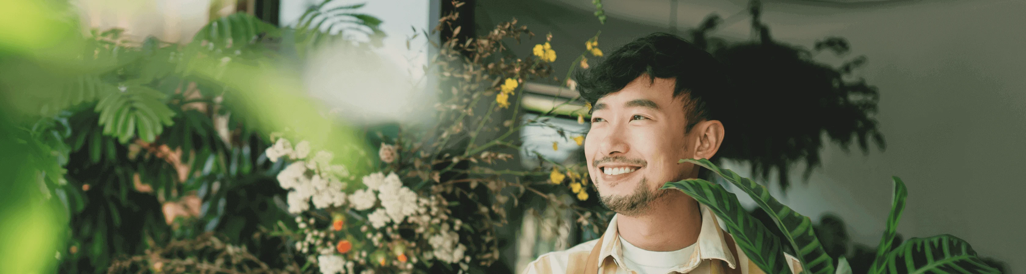 Smiling man standing in a flower shop