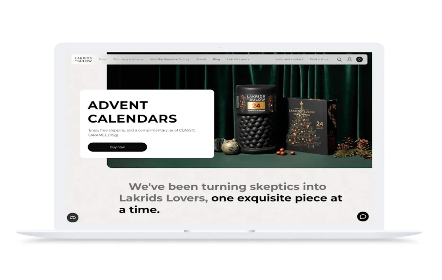 Laptop displaying Lakrids by Bülow website featuring advent calendars with dark green background and holiday decorations.