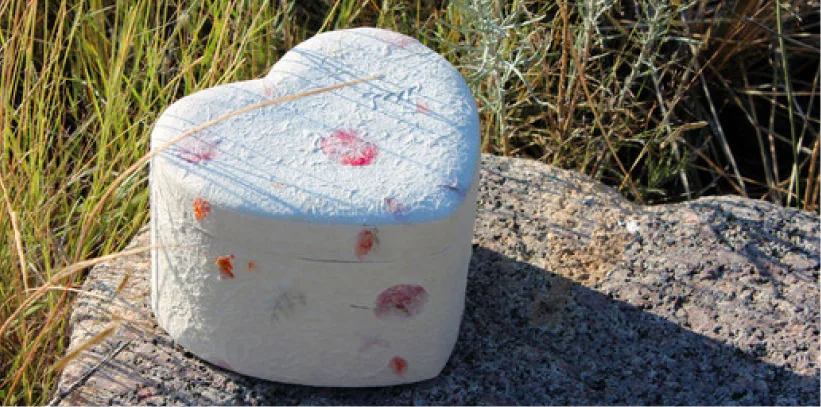 Heart-shaped biodegradable cremation urn placed outdoors, designed for eco-friendly memorial services.