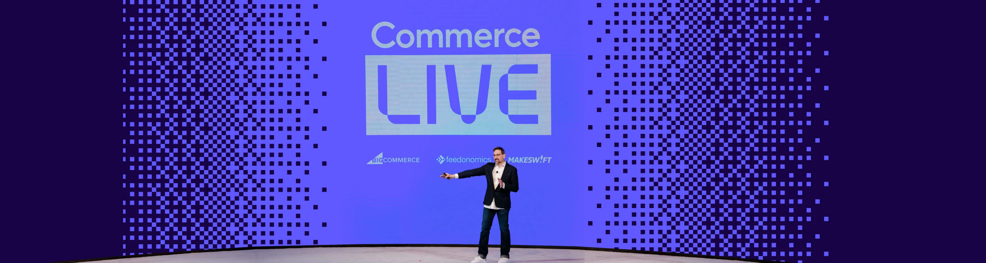 Commerce LIVE event stage with a presenter beneath large event branding and partner logos for BigCommerce, Feedonomics, and Makeswift.
