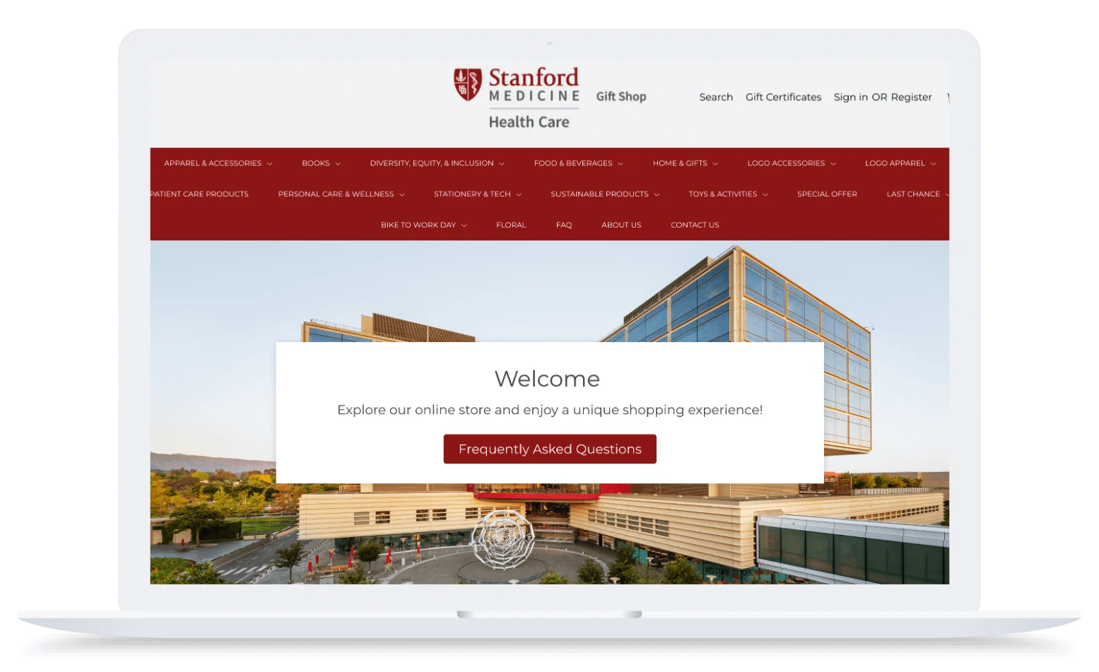 Laptop screen displaying the Stanford Medicine Health Care Gift Shop website with a pop-up welcome message over an image of the hospital building.
