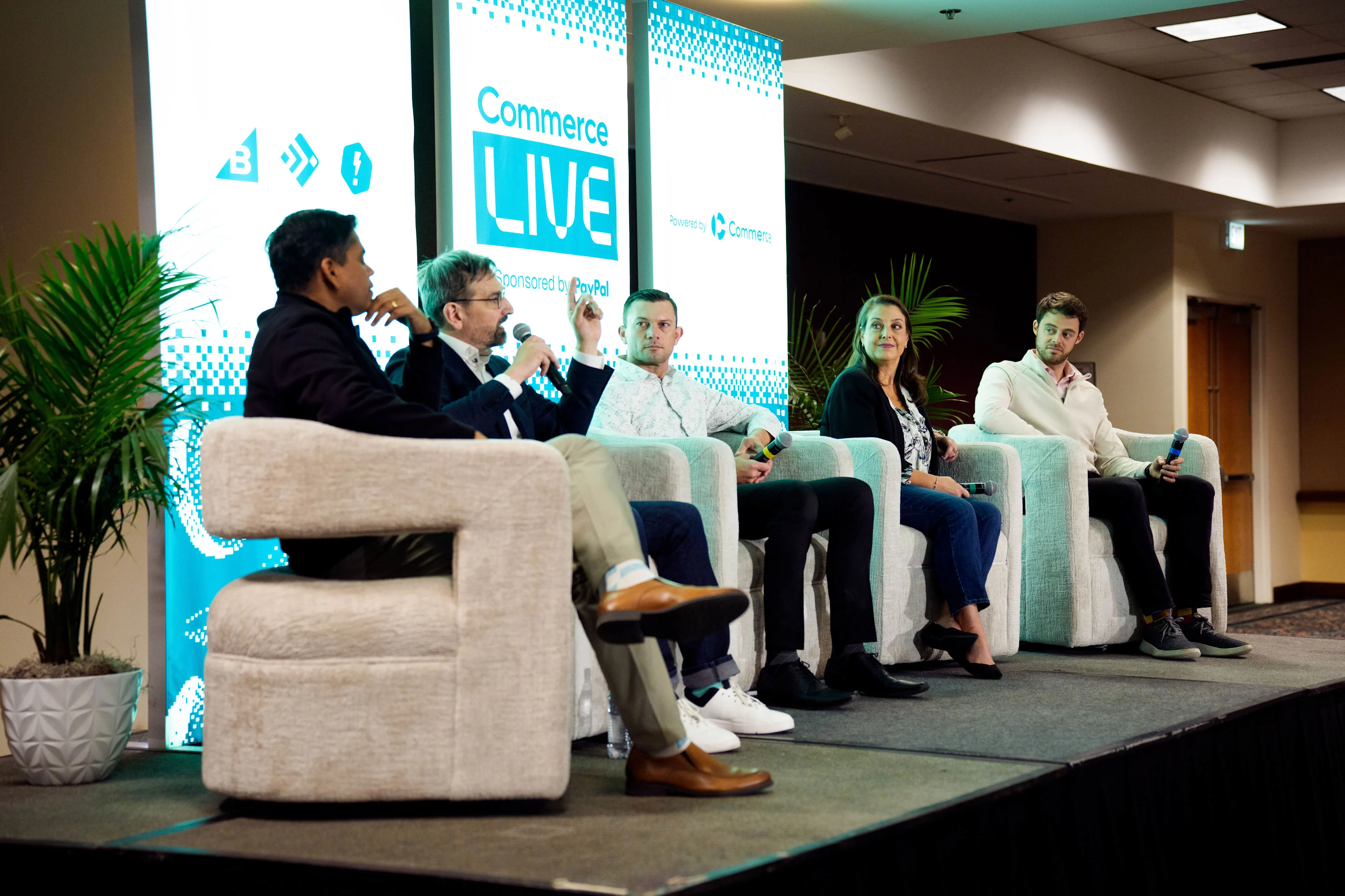 Live conference panel discussion on stage beneath Commerce LIVE 2026 and PayPal sponsorship signage.