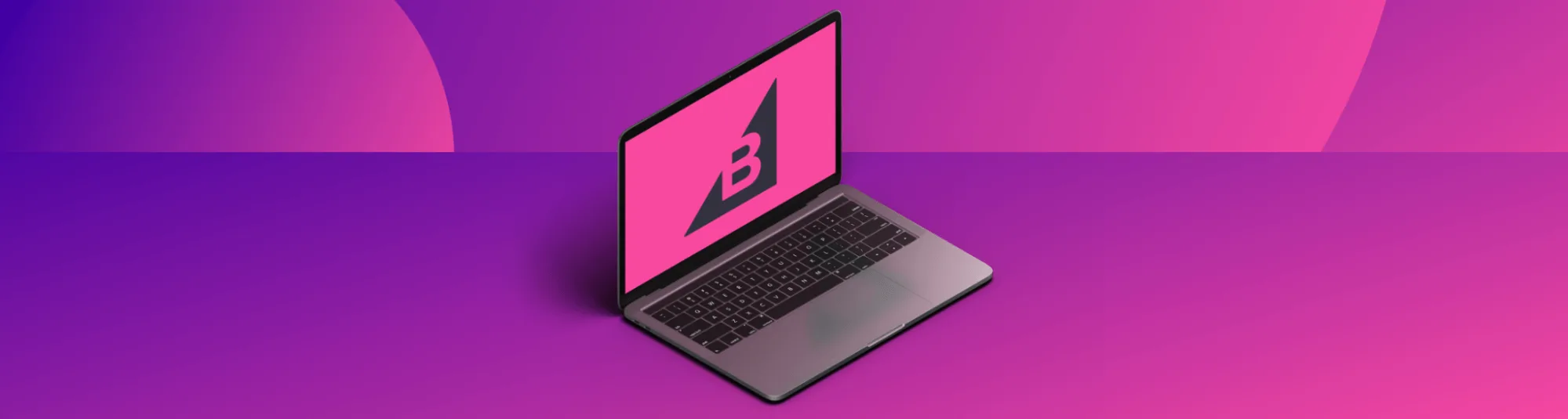 Open laptop on a purple and pink gradient surface, screen displaying a bold B logo on a bright pink background.