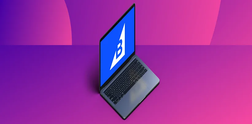 Open laptop with a blue screen displaying a white BigCommerce logo, on a purple and pink gradient background.