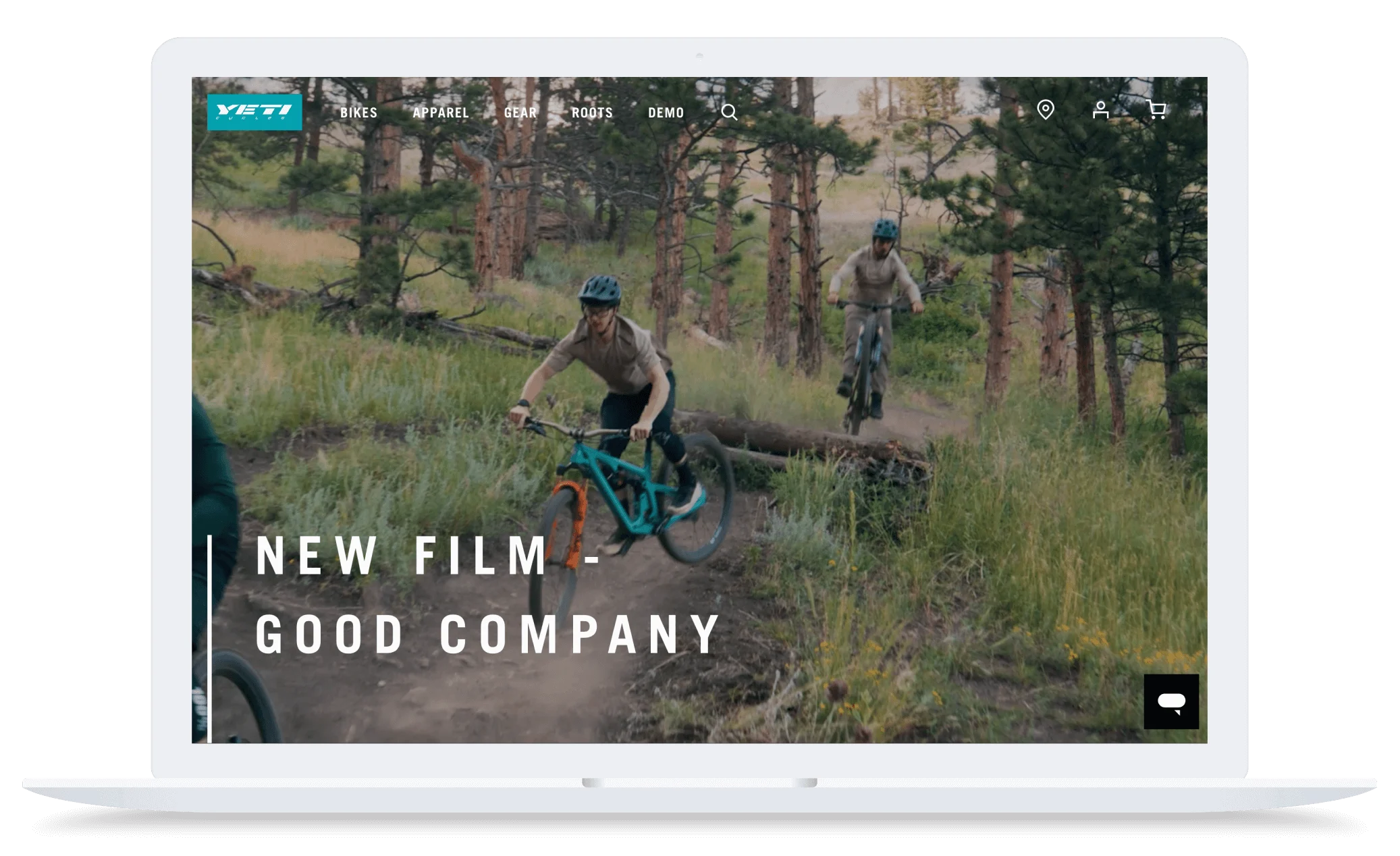 Two mountain bikers ride on a forest trail, one jumping over a log, with text "New Film - Good Company" on screen.