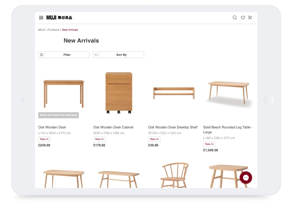 Tablet screen showing MUJI’s website with new arrivals of wooden furniture, including desks, tables, and chairs.