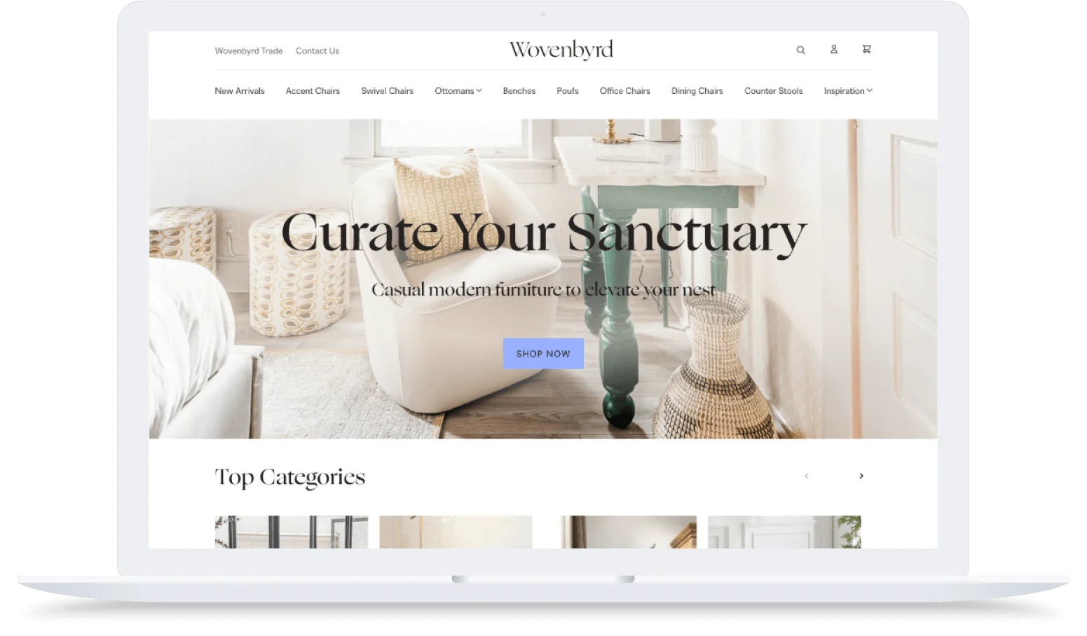 Laptop displaying a modern furniture website with a cozy living room scene and a "Curate Your Sanctuary" headline.