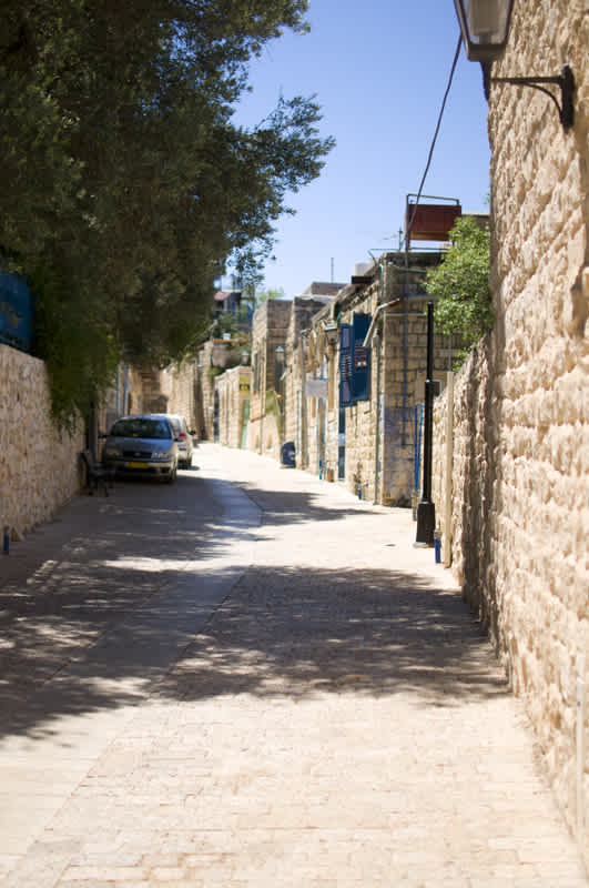 Road with cars parked on the side in Tzfat, Israel. 