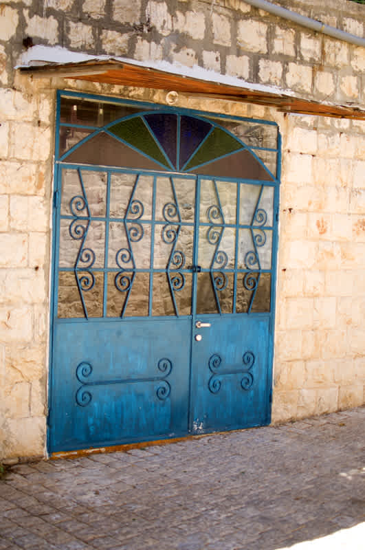 Blue door decorated with stained glass and metal work in Tzfat, Israel. 