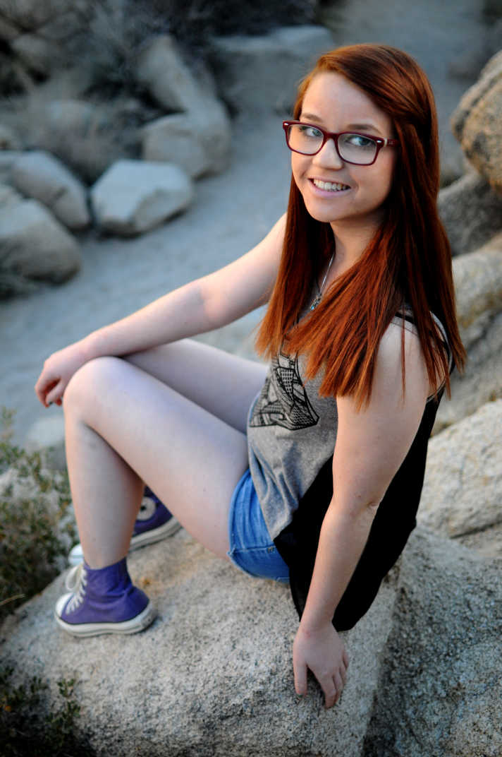 Girl sitting on a rock.