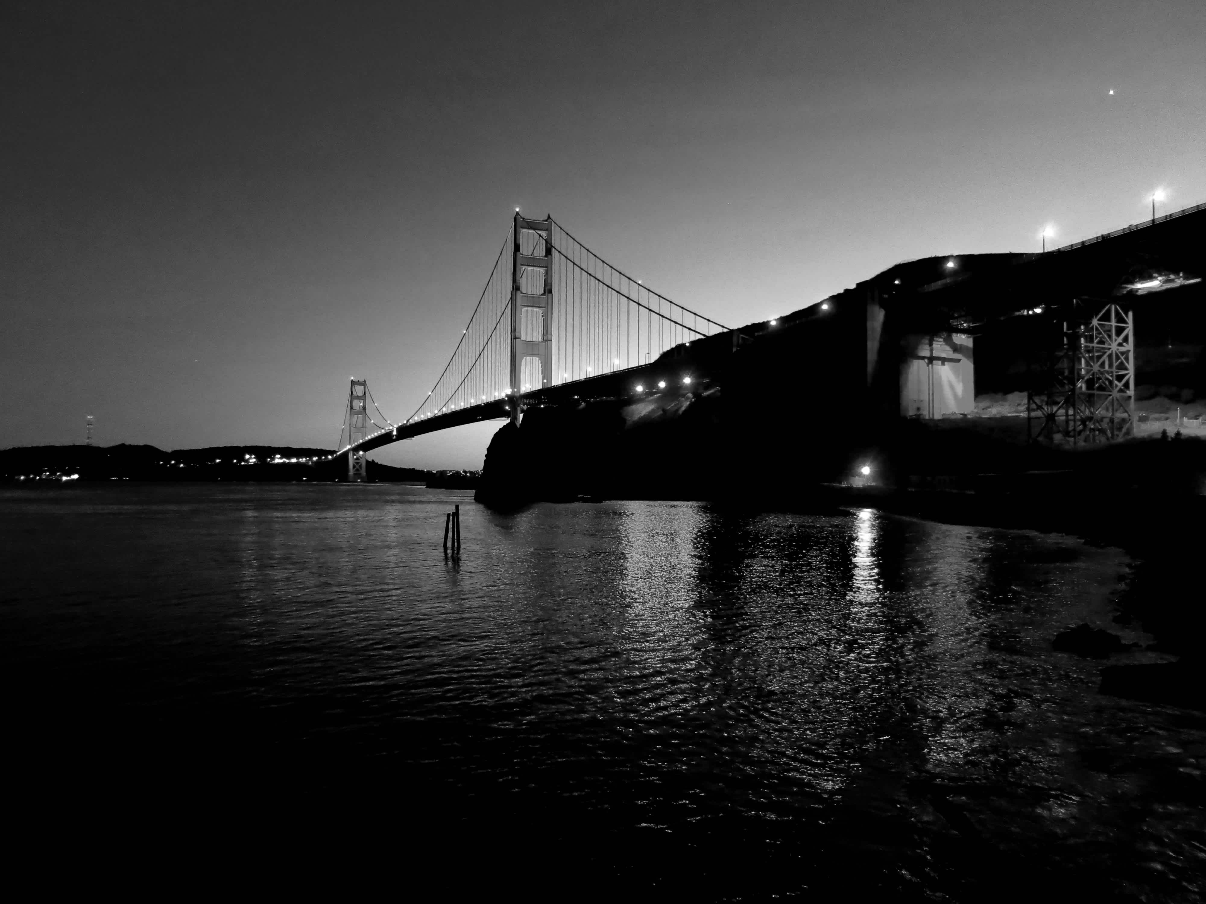 Golden Gate bridge with city reflected in the water in black and white in Golden Gate Bridge, San Francisco, California.