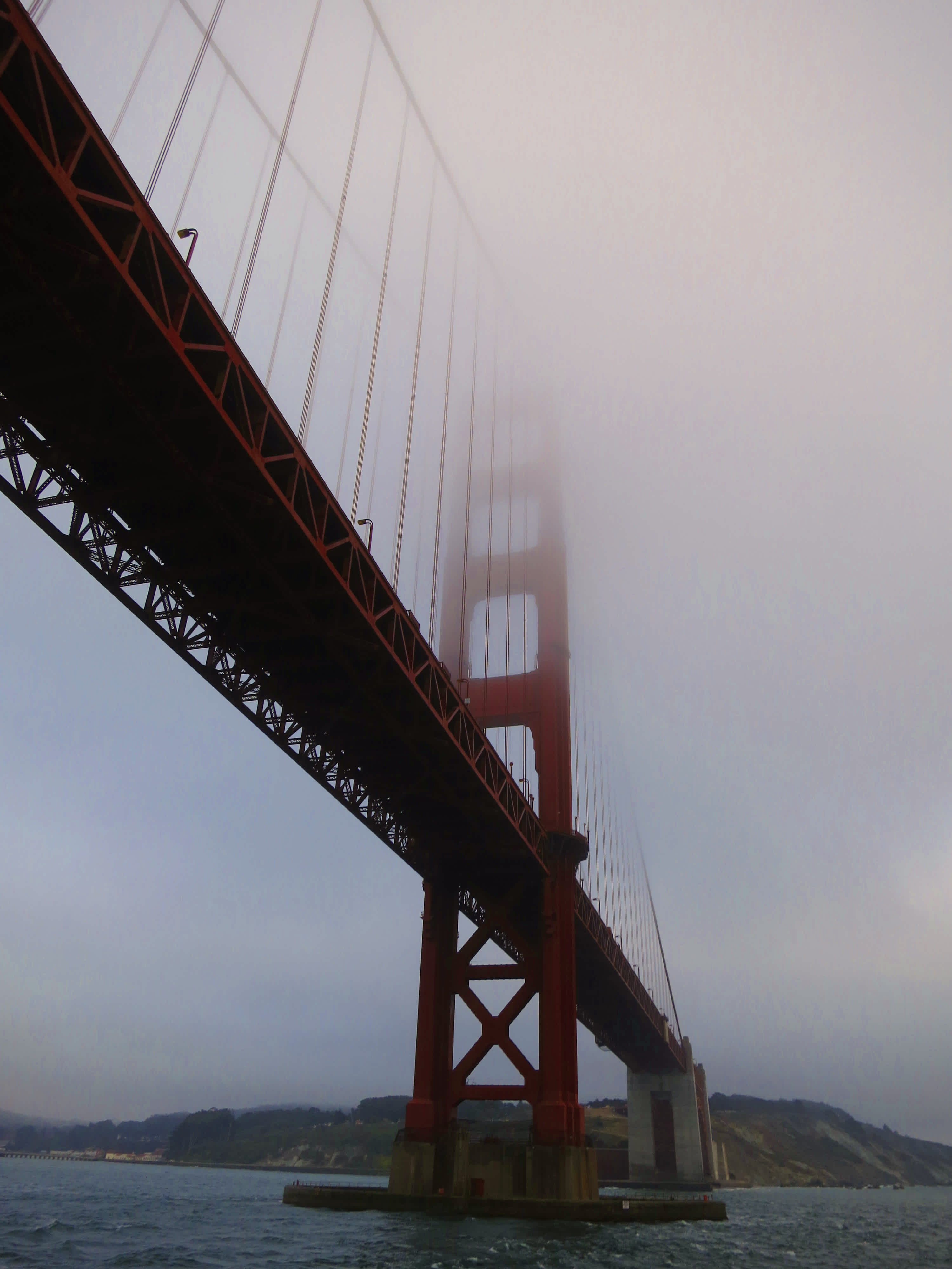 Golden Gate Bridge shot from below with slight fog in the sky in Golden Gate Bridge, San Francisco, California. 
