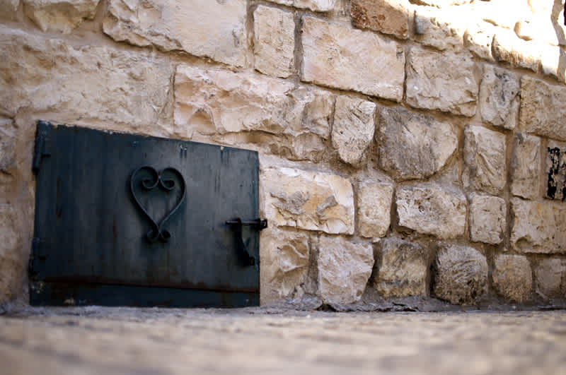 Decorative small door in a stone wall with a metal worked heart on it in Tzfat, Israel. 