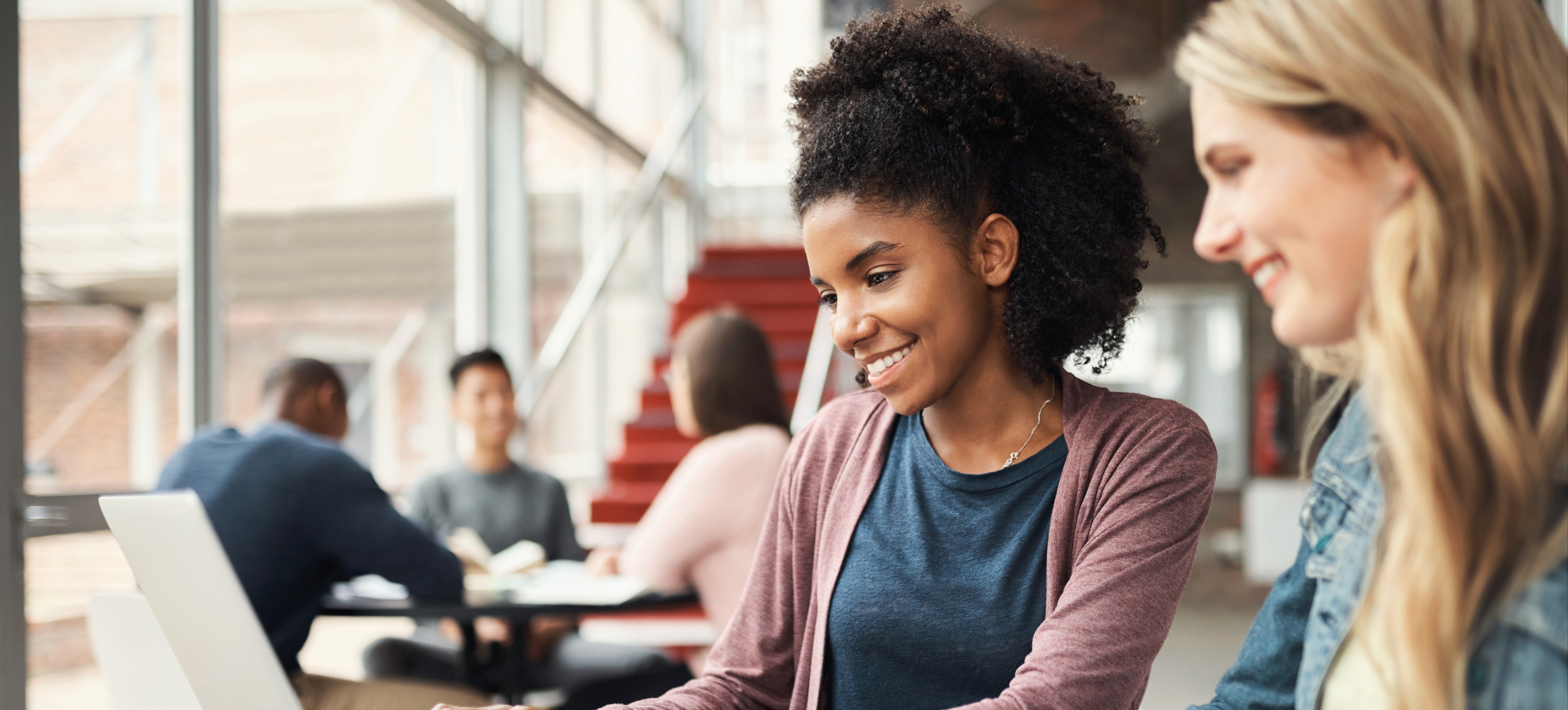 [Featured Image] Two students with no bachelor’s degree study for a master’s in engineering in the library at their university.
