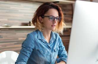 [Featured Image] A woman sits at a computer and learns about using artificial intelligence to benefit her career.