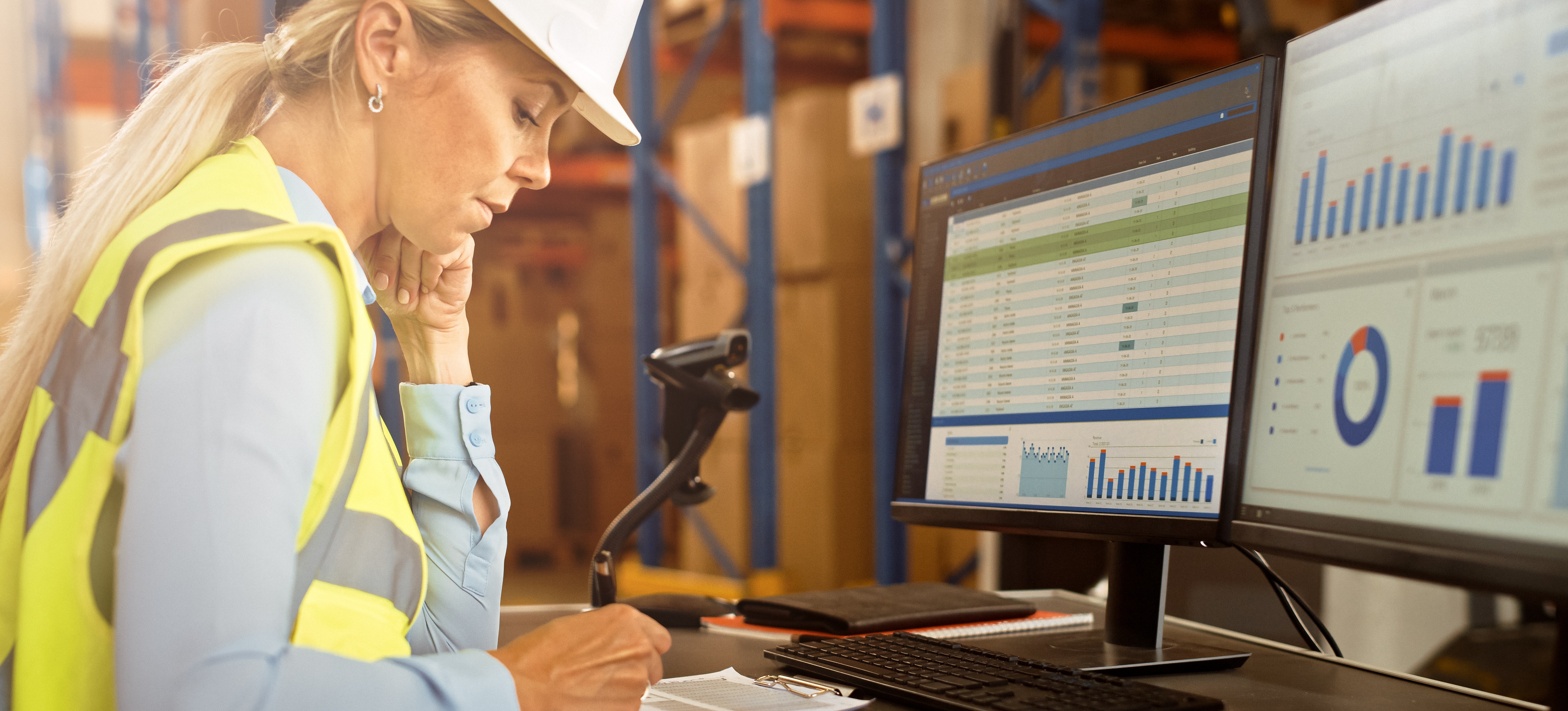 [Featured Image] A logistics analyst reviews data displayed on computer screens to assist with supply chain management.
