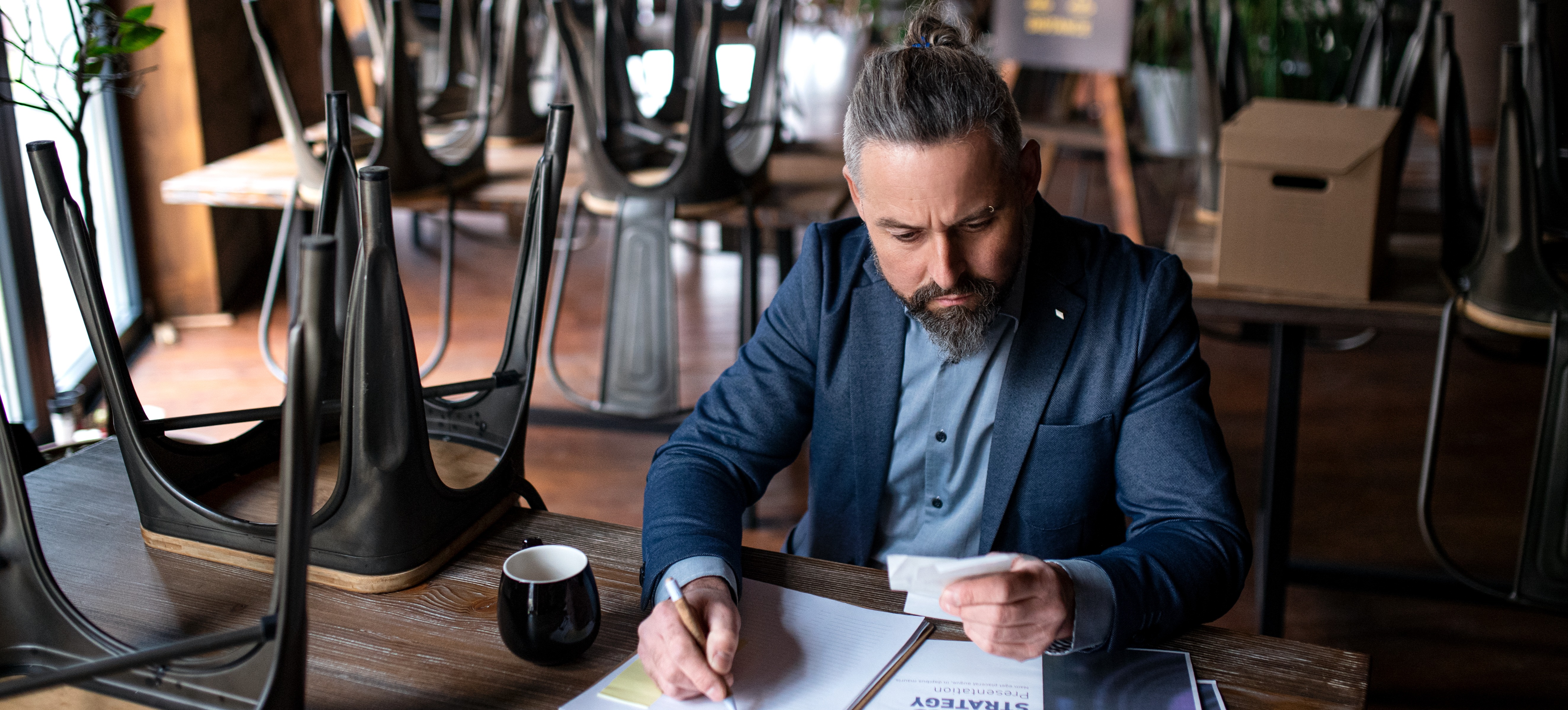 [Featured image] A man reviews income and expenses as he considers what recession means.
