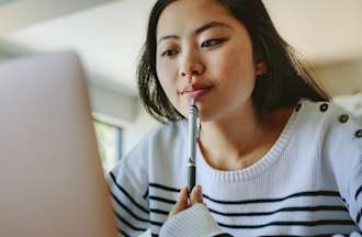 [Featured image] A learner in a striped sweater researches computer science vs. information technology majors on a laptop. 