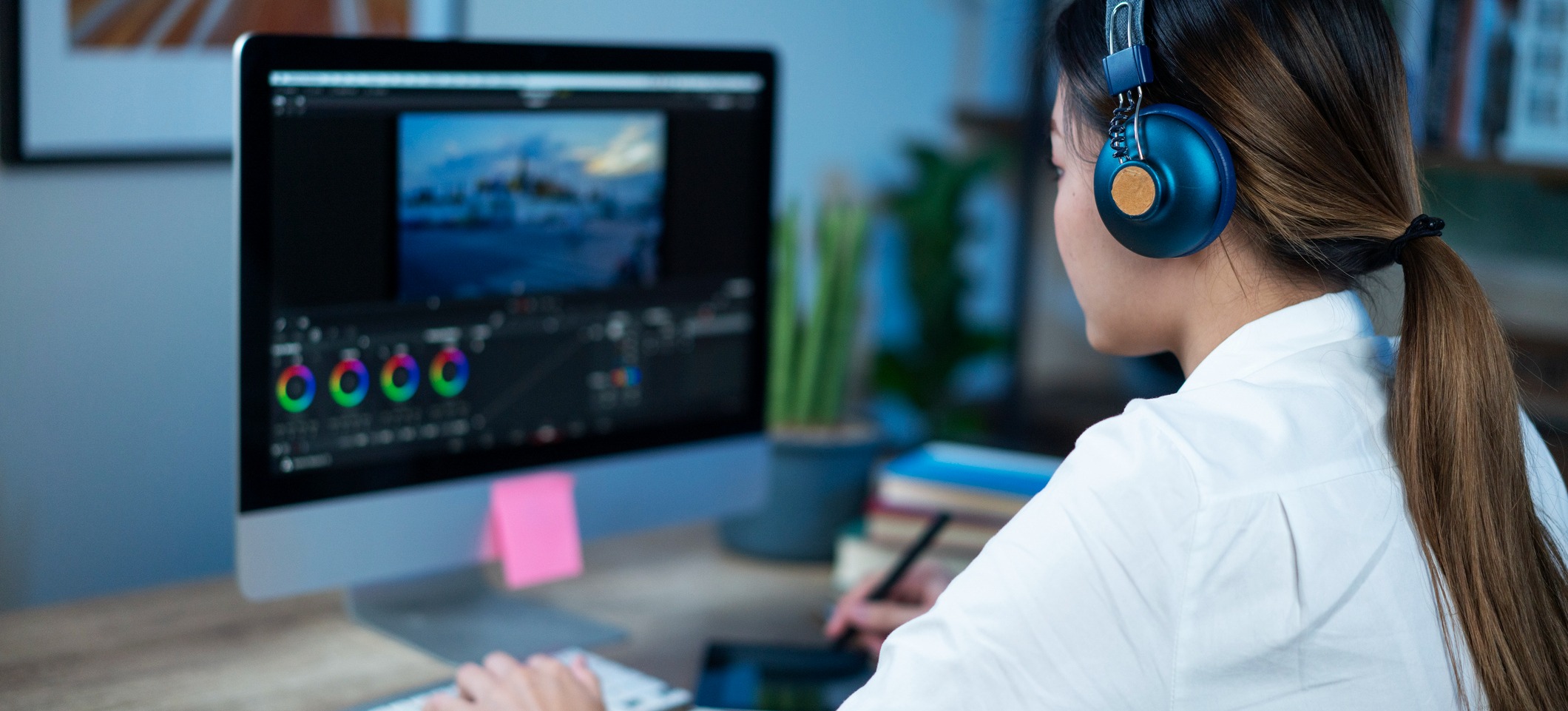 [Featured image] A video editing professional works on her laptop computer in a home studio.