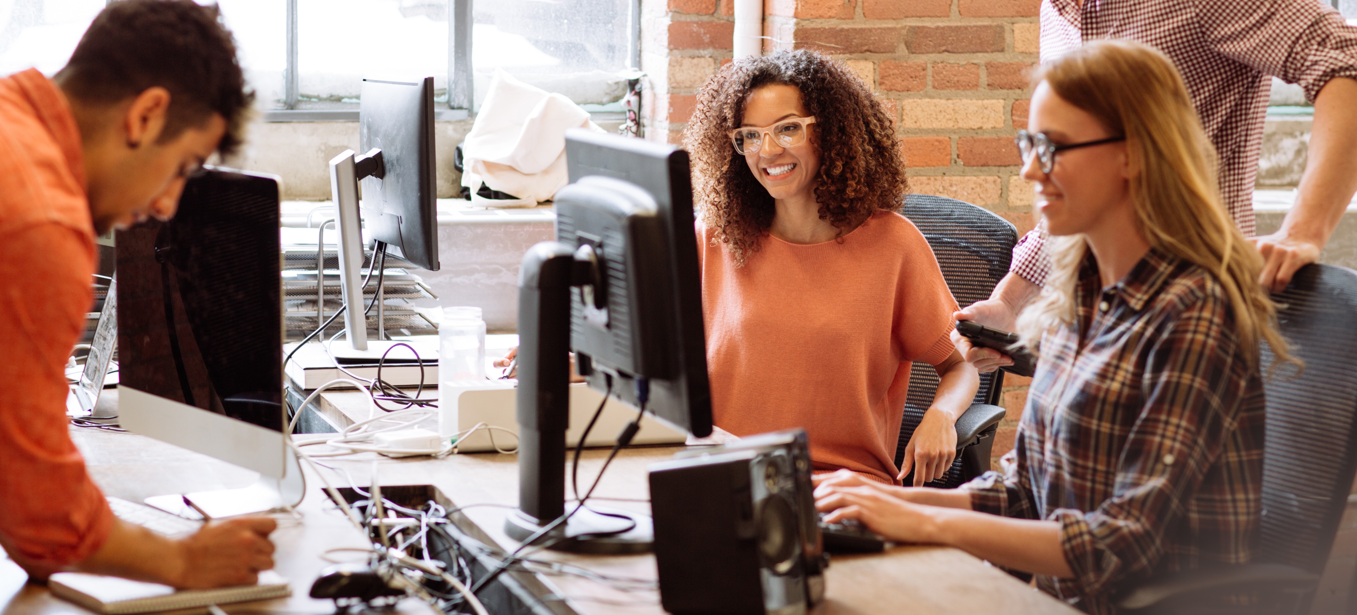 [Featured Image] An AR developer sits in a workspace, collaborating with a software development team.