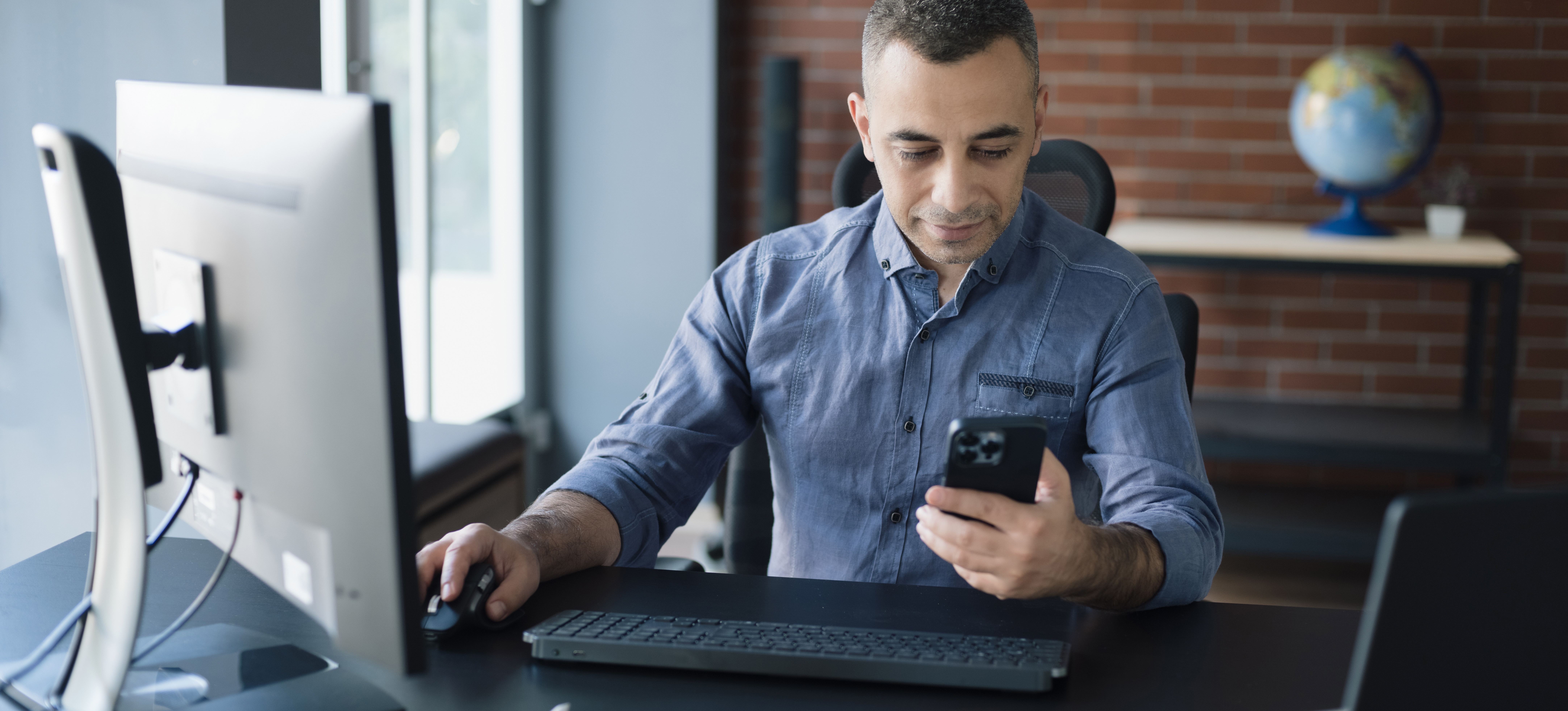 [Featured Image] A business man in his office is learning how to invest in the metaverse.