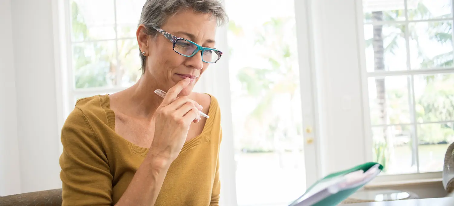 [Featured Image] A finance professional sits at a workspace, preparing to earn a risk analyst certification.